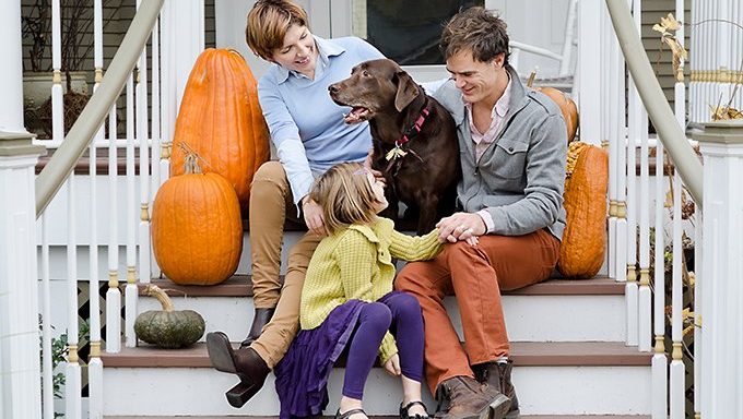 Familie auf Treppen mit Hund und Kürbissen