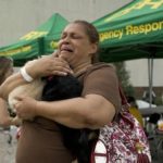 woman holds cats at natural disaster shelter