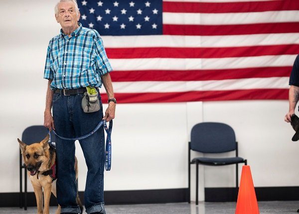 Michael Kidd, and his service dog Millie wait for their training at the Paws of War office in Nesconset, Long Island, New York on June 10, 2019. - The service dogs are either trained or being trained to help veterans through difficult times by Paws of War, an association funded entirely by private donations that provides the shelter animals free of charge.
