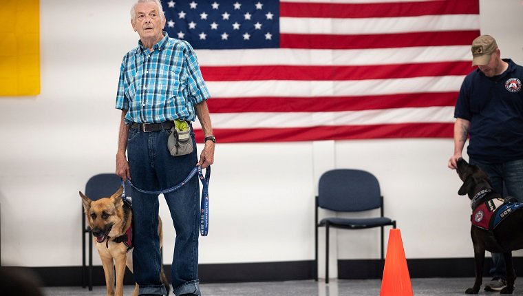 Michael Kidd, and his service dog Millie wait for their training at the Paws of War office in Nesconset, Long Island, New York on June 10, 2019. - The service dogs are either trained or being trained to help veterans through difficult times by Paws of War, an association funded entirely by private donations that provides the shelter animals free of charge.
