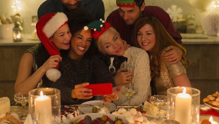 Hund am Tisch mit Familie unter Selfie zu Weihnachten