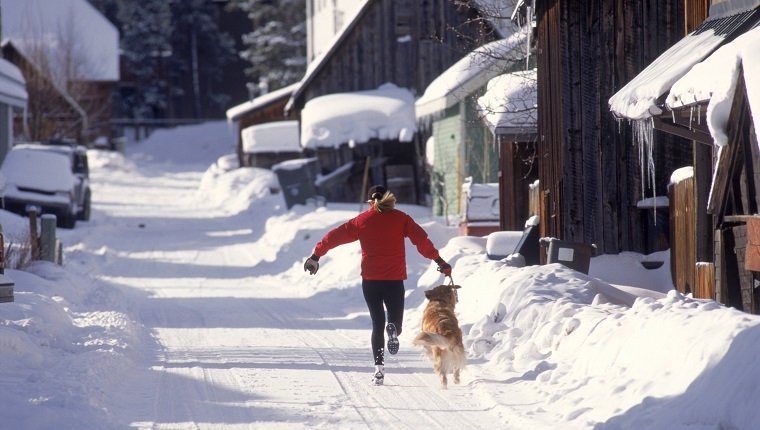 Frau läuft mit Hund, Breckenridge, CO