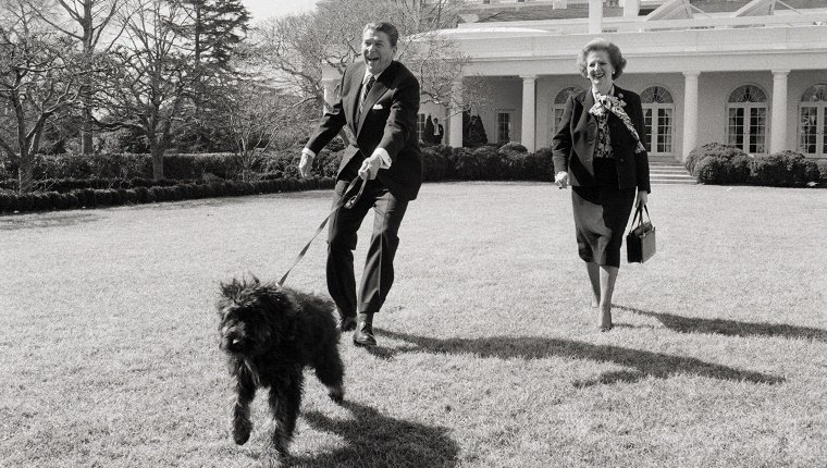 Präsident Ronald Reagan und die britische Premierministerin Margaret Thatcher bringen Reagans Hund Lucky auf den Rasen des Weißen Hauses.
