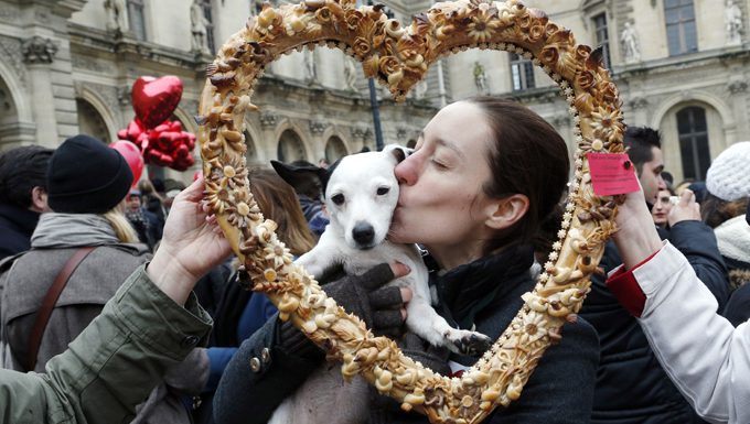 Frau küsst Hund beim Festival