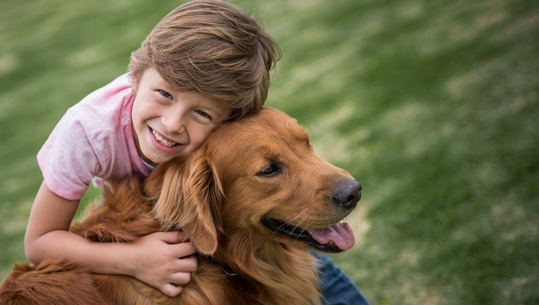 Porträt eines glücklichen Jungen im Freien mit einem schönen Hund - Lebensstilkonzepte