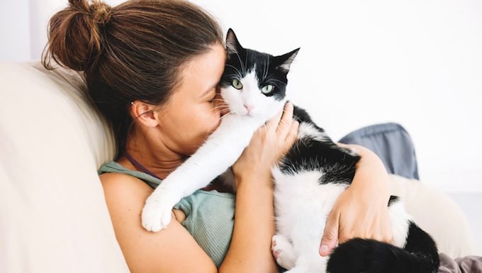 Frau umarmt Katze