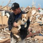 MOORE, OK - MAY 21: Sean Xuereb recovers a dog from the rubble of a home that was destroyed by a tornado on May 21, 2013 in Moore, Oklahoma. The town reported a tornado of at least EF4 strength and two miles wide that touched down yesterday killing at least 24 people and leveling everything in its path. U.S. President Barack Obama promised federal aid to supplement state and local recovery efforts.