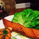 High Angle View Of Salmon In Plate On Table By Dog