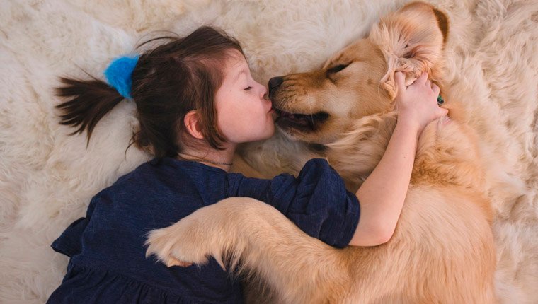 junges Mädchen küsst ihren Hund