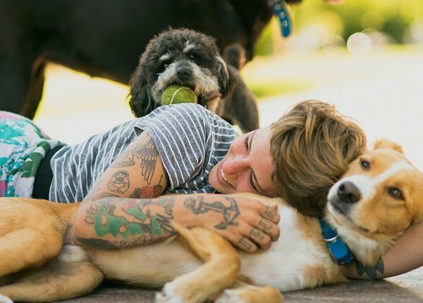 Tattoed woman relaxing with dogs at the park