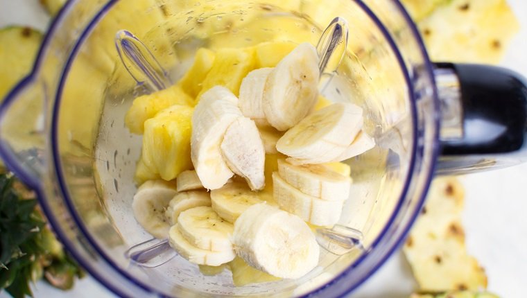 Ananas und Banane in Scheiben geschnitten in einem Mixer