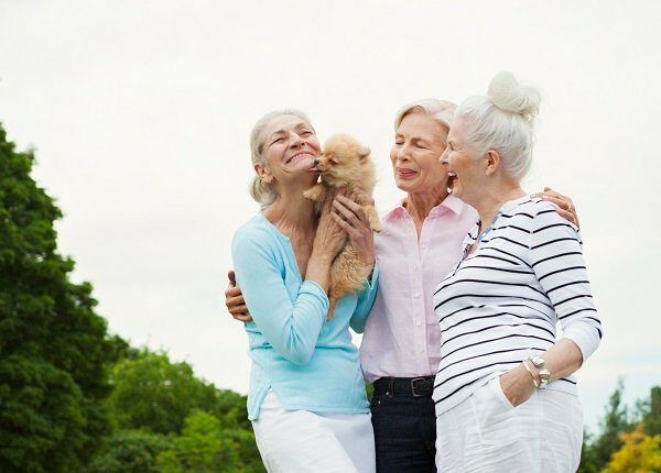 Senior women holding dog in park