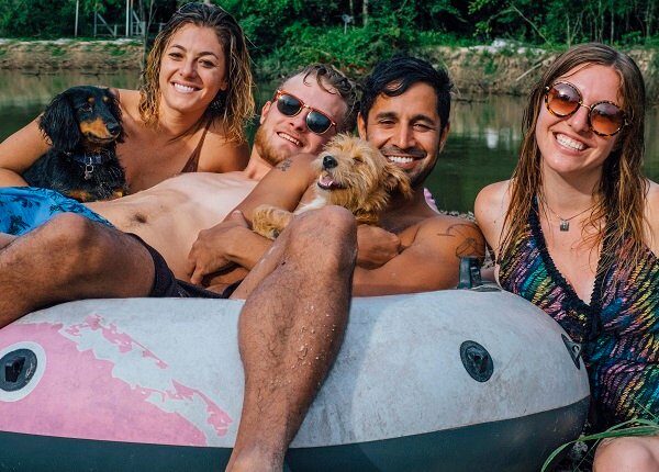 Two Adult Males with Two Adult Females and Two Dogs sitting in a floaty by Ponchatoula Creek after a day of tubing down the river in Southern Louisiana.