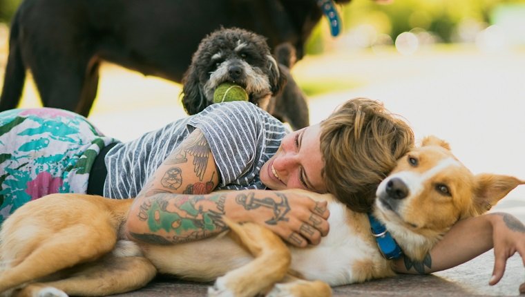 Tattoed woman relaxing with dogs at the park