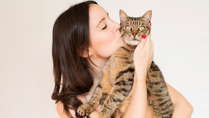 Frau, die Katze küsst