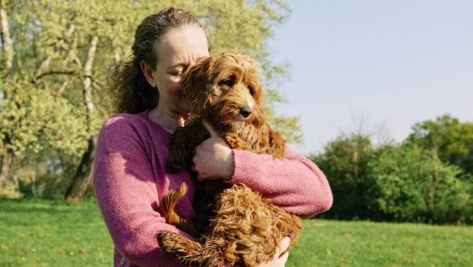 Frau umarmt Hund Frühling Haustierpflegetipps